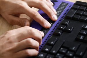 Blind person using computer with braille computer display